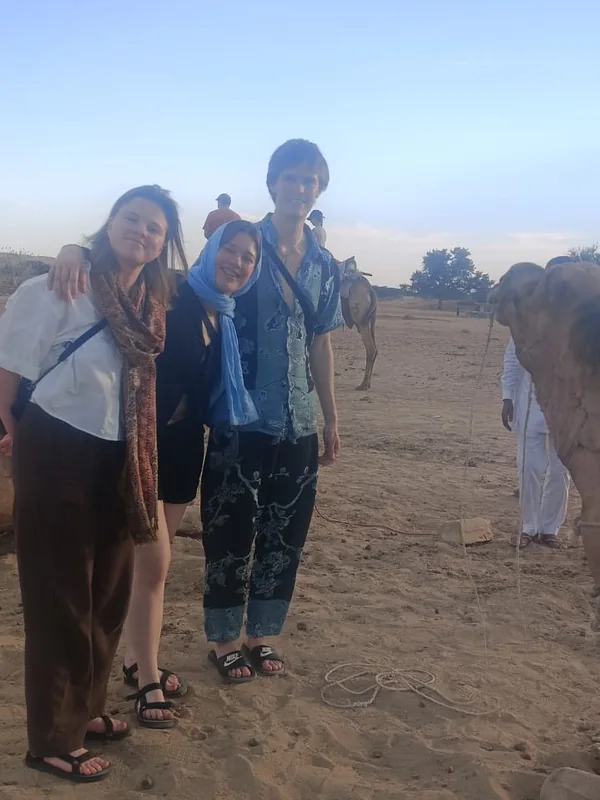 Three guests beside the camels on a Thar Desert safari